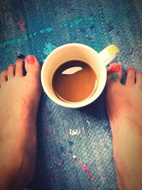 Low section of woman holding coffee cup