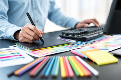 Midsection of businesswoman working on table