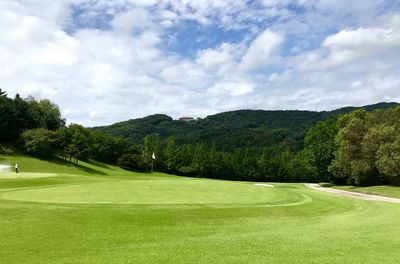 Scenic view of golf course against sky