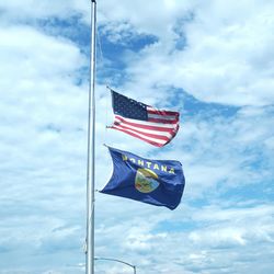 Low angle view of american flag against cloudy sky