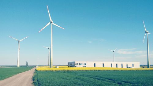 Windmill on field against clear sky