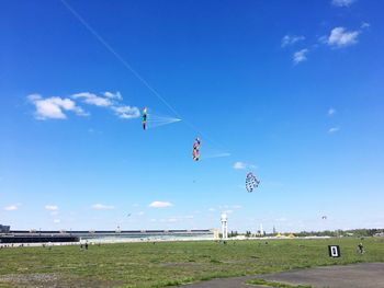 Scenic view of vapor trails against blue sky