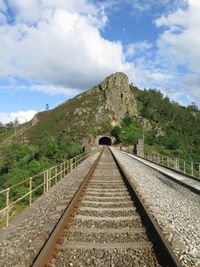 Railroad track against cloudy sky