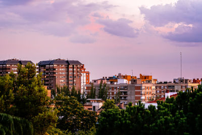 View of buildings in city against cloudy sky