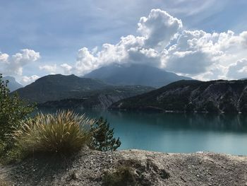 Scenic view of lake by mountains against sky