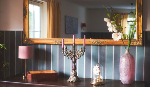 Flower vase on table by window at home