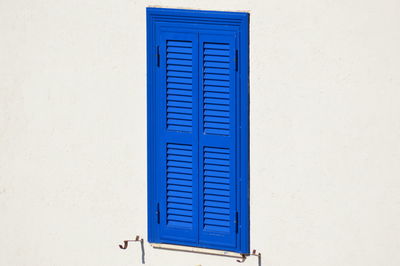 Close-up of blue window on white wall