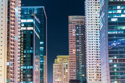 Low angle view of illuminated buildings in city at night