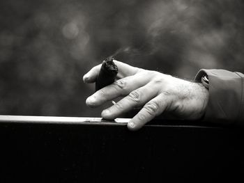 Close-up of man holding cigarette
