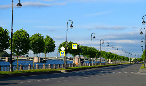 Street lights by road against sky