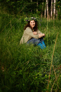 Portrait of young woman sitting on grassy field