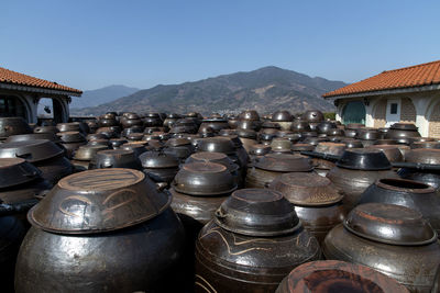 Close-up of jars and buildings against sky