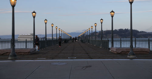 Street lights on bridge against sky