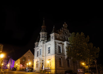 Low angle view of illuminated building against sky at night