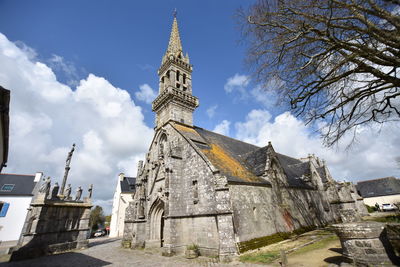 Low angle view of cathedral amidst buildings against sky