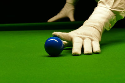 Cropped hands touching ball on pool table