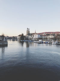 Bridge over river against buildings in city