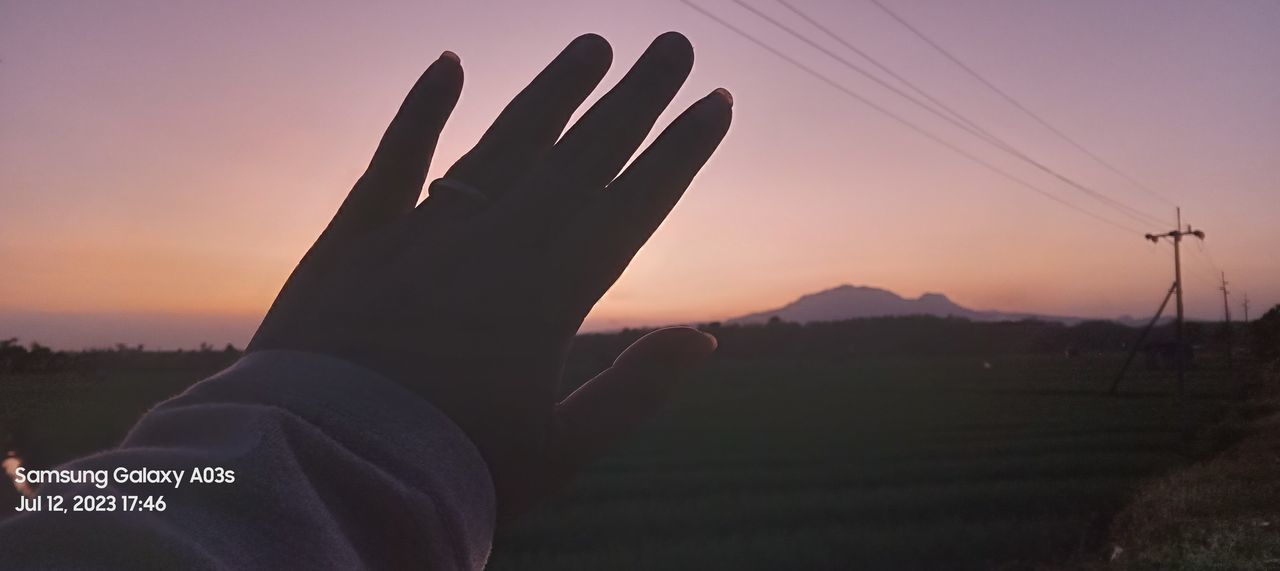 sky, sunset, hand, one person, nature, silhouette, technology, landscape, environment, beauty in nature, outdoors, scenics - nature, dusk, personal perspective, communication, finger, lifestyles