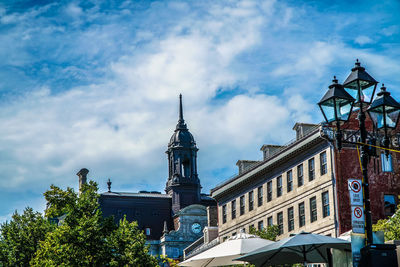 Low angle view of trees and buildings against sky