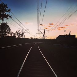 Railroad tracks against sky at sunset