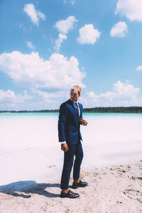 Full length of man standing on beach against sky