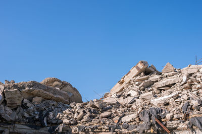 Low angle view of rock formations against clear blue sky