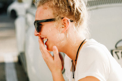 Close-up of woman wearing sunglasses while smiling outdoors