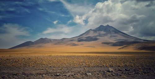 View of desert against cloudy sky