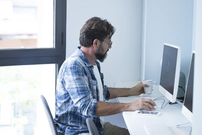 Side view of man working on table