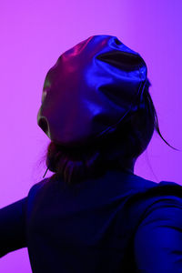 Close-up portrait of woman against blue background