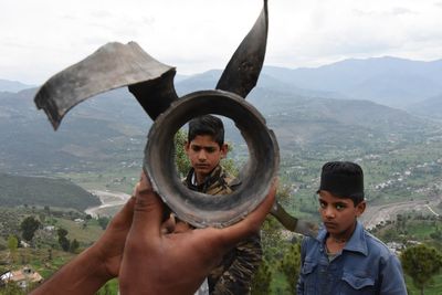 Portrait of man holding camera against mountains