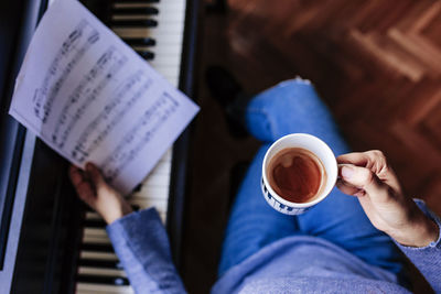 Happy woman with coffee cup holding sheet