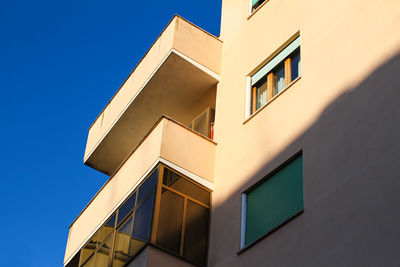 Urban construction in rome, residential building, painted yellow, blue sky.