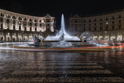 Fountain in city at night