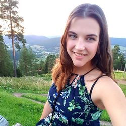 Portrait of smiling young woman against plants