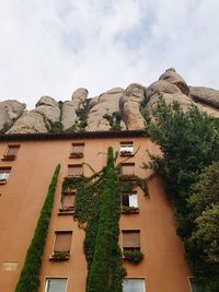 Low angle view of trees and buildings against sky