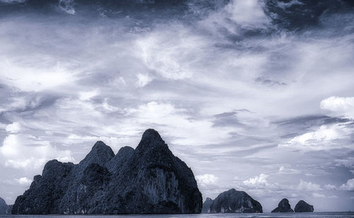 Rock formations against cloudy sky