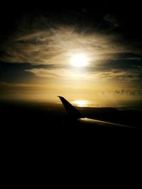 Silhouette of airplane flying over sea