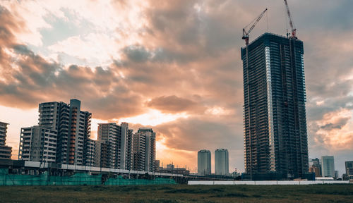 Modern buildings against sky during sunset