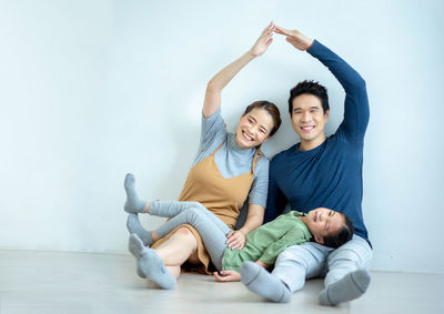 Portrait of happy friends sitting on floor