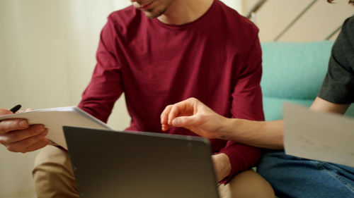 Midsection of man using mobile phone