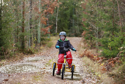Boy cycling through forest