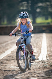 Cheerful girl riding bicycle on land