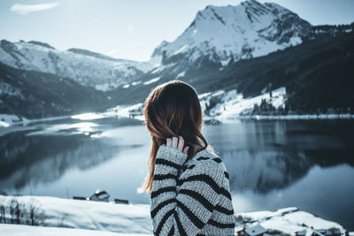 Woman against snow covered mountains and sky during winter