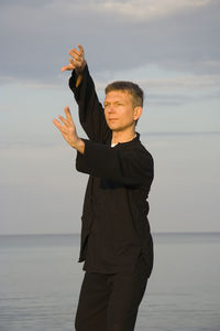 Man standing by sea against sky