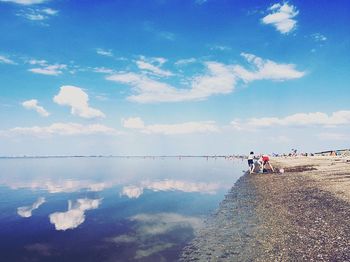 People on beach against sky