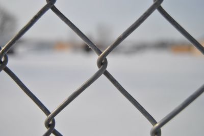 Close-up of chainlink fence against sky