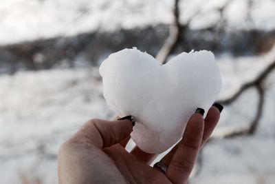 Close-up of hand holding heart shape ice