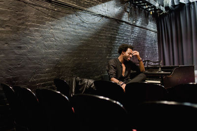 Musician sitting at a piano in a small theater