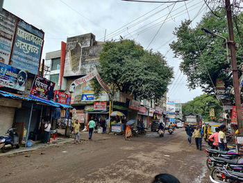 People on street against buildings in city